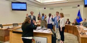 Larry Mboga (in brown jacket) and other memebers of the Eau Claire City Council members take an oath of office on April 20, 2022..jpg