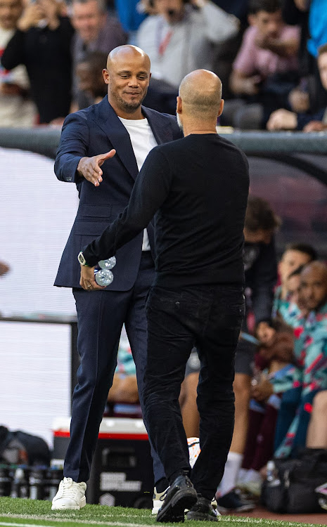 Burnley's manager Vincent Kompany shakes hands with Manchester City manager Pep Guardiola on August 11, 2023