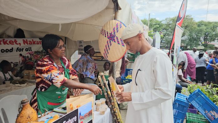 A farmers sells her organically grown produce to a resident during the Nakuru Organic Food Expo.